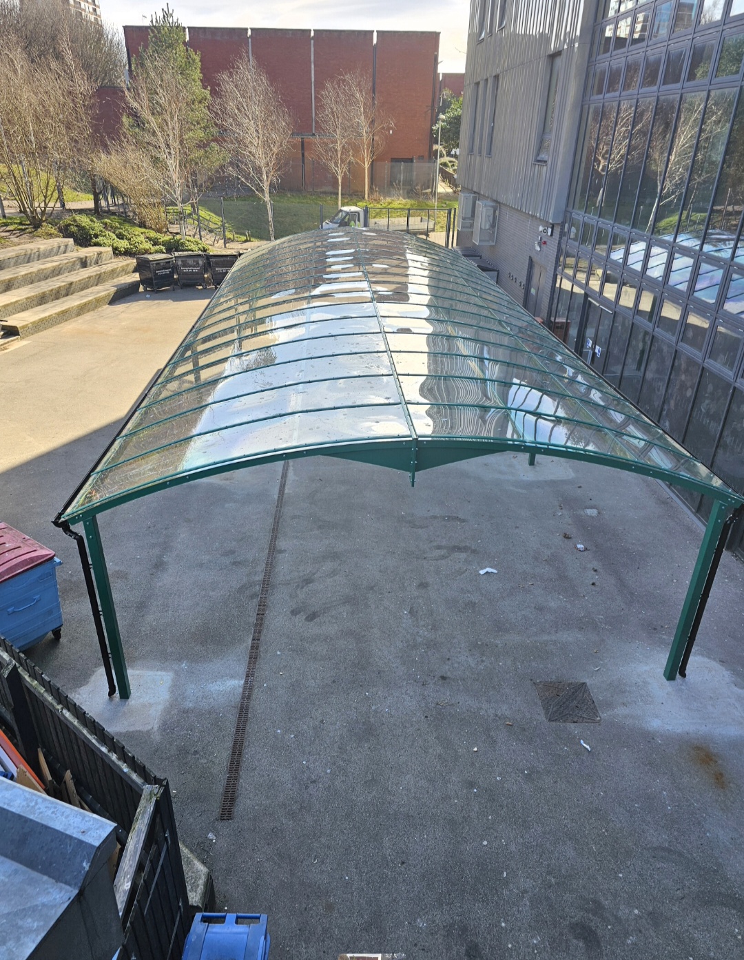 Looking along the top of the green canopy's clear curved polycarbonate roof from above