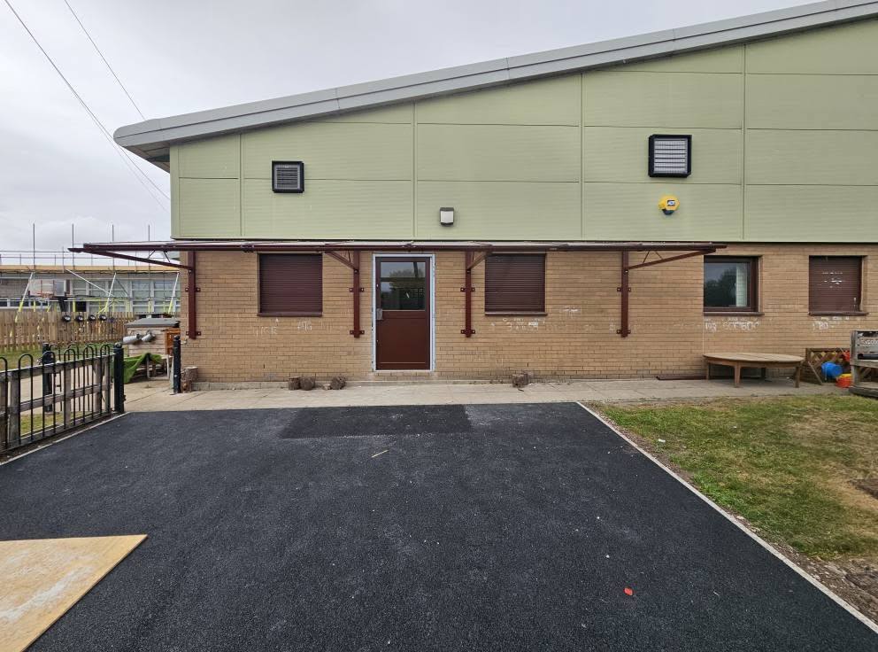 Front view of the brown wall-mounted cantilever canopy above the entrance and windows