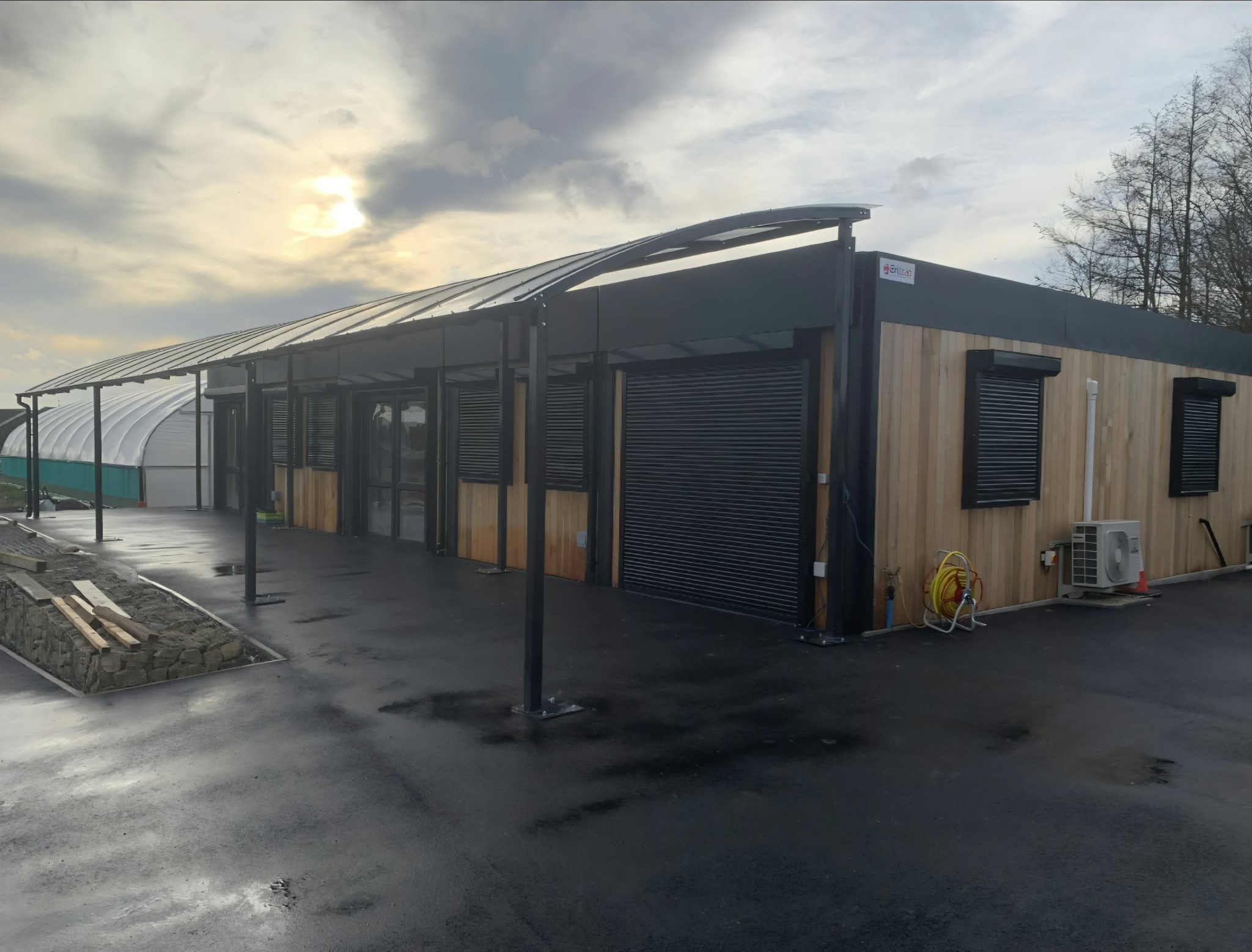 Angled view of the curved cantilever canopy along the timber-clad school building from the yard