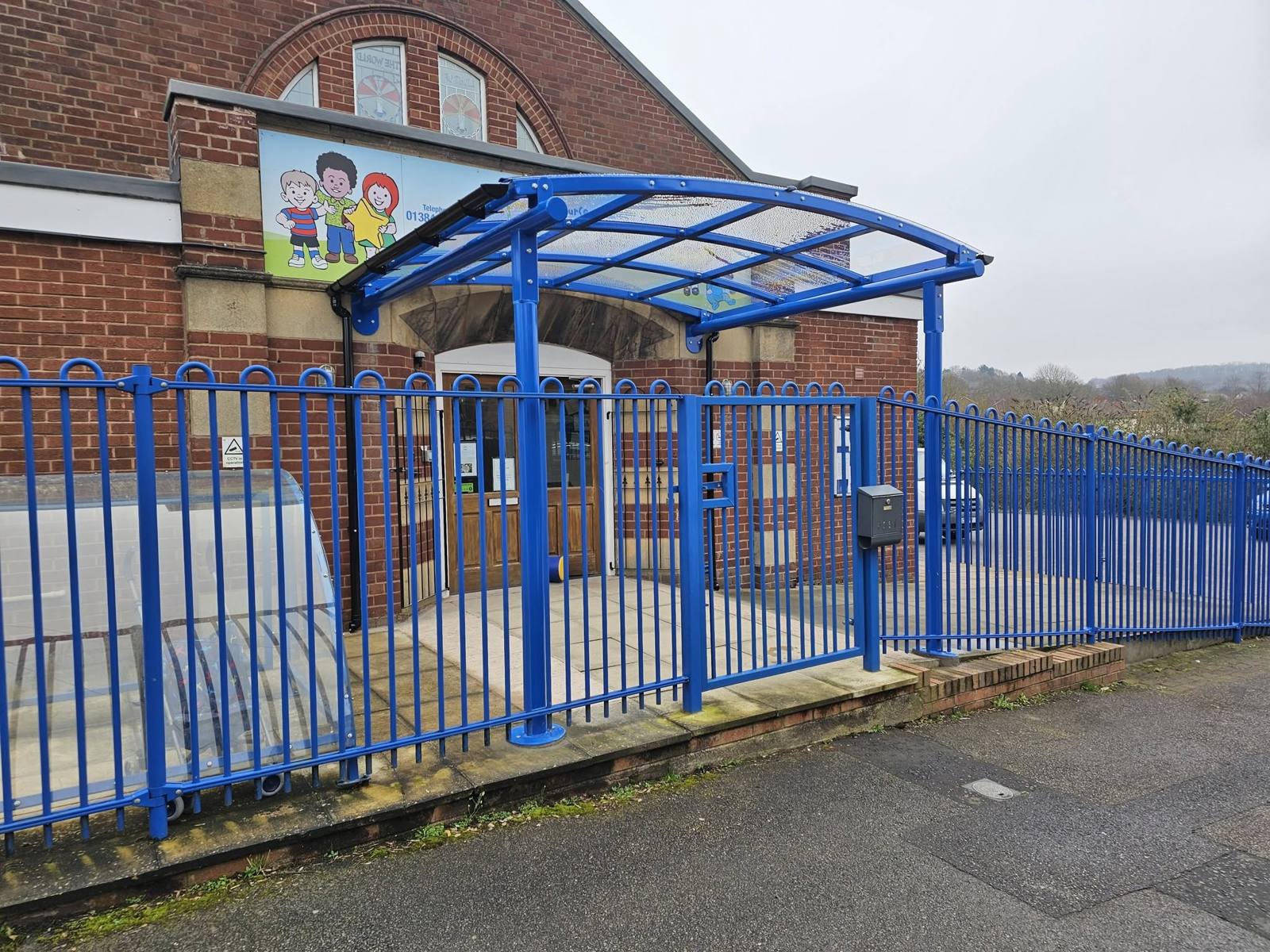 Curved entrance canopy over the gated entrance to Shine Nursery