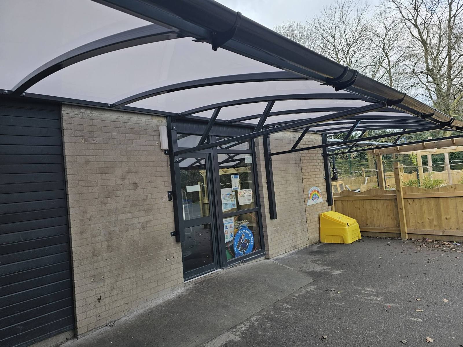 Dark cantilever nursery canopy over the early years entrance doors at St Luke’s CE Primary School, Heywood