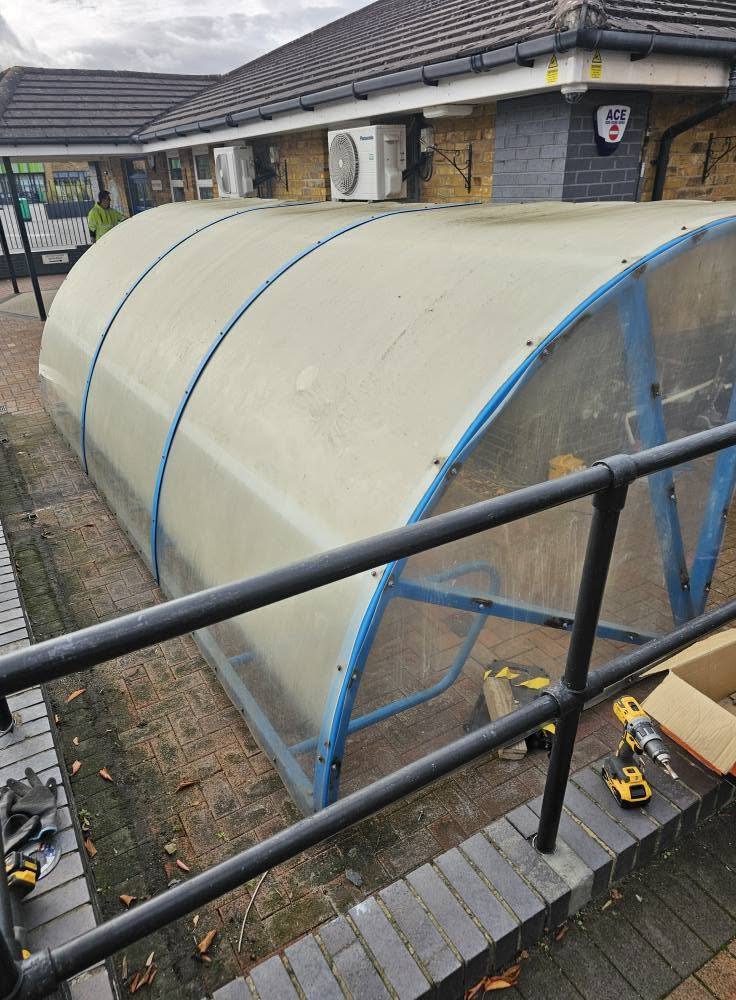 Side view of the curved cycle shelter with new cladding and tools by the handrail at Stewart Fleming Primary School