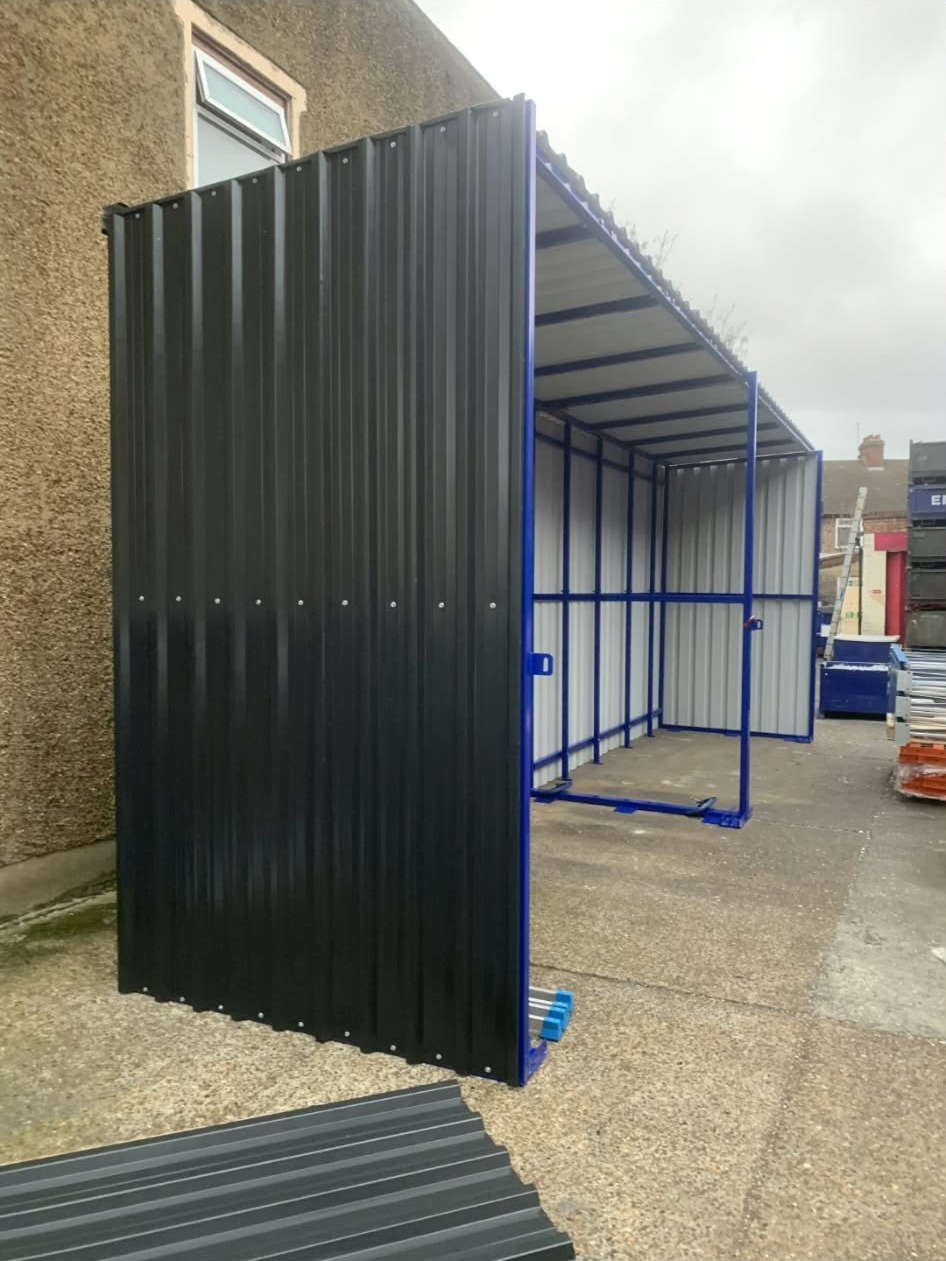 A corrugated sliding door slid open, revealing the lined interior and blue steel framing inside the shelter
